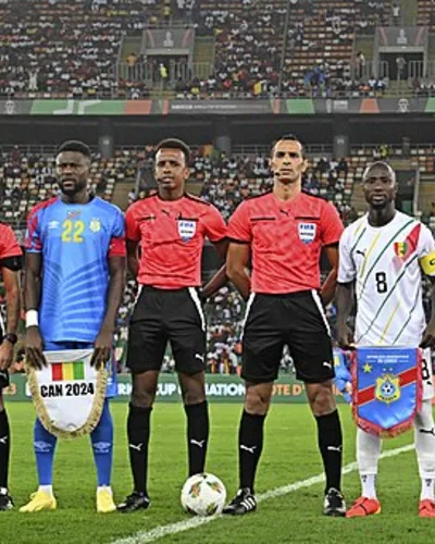 Chancel Mbemba — Captains Chancel Mangulu Mbemba of DR Congo and Naby Keita of Guinea pose with referee Mustapha Ghorbal and his match officials before the